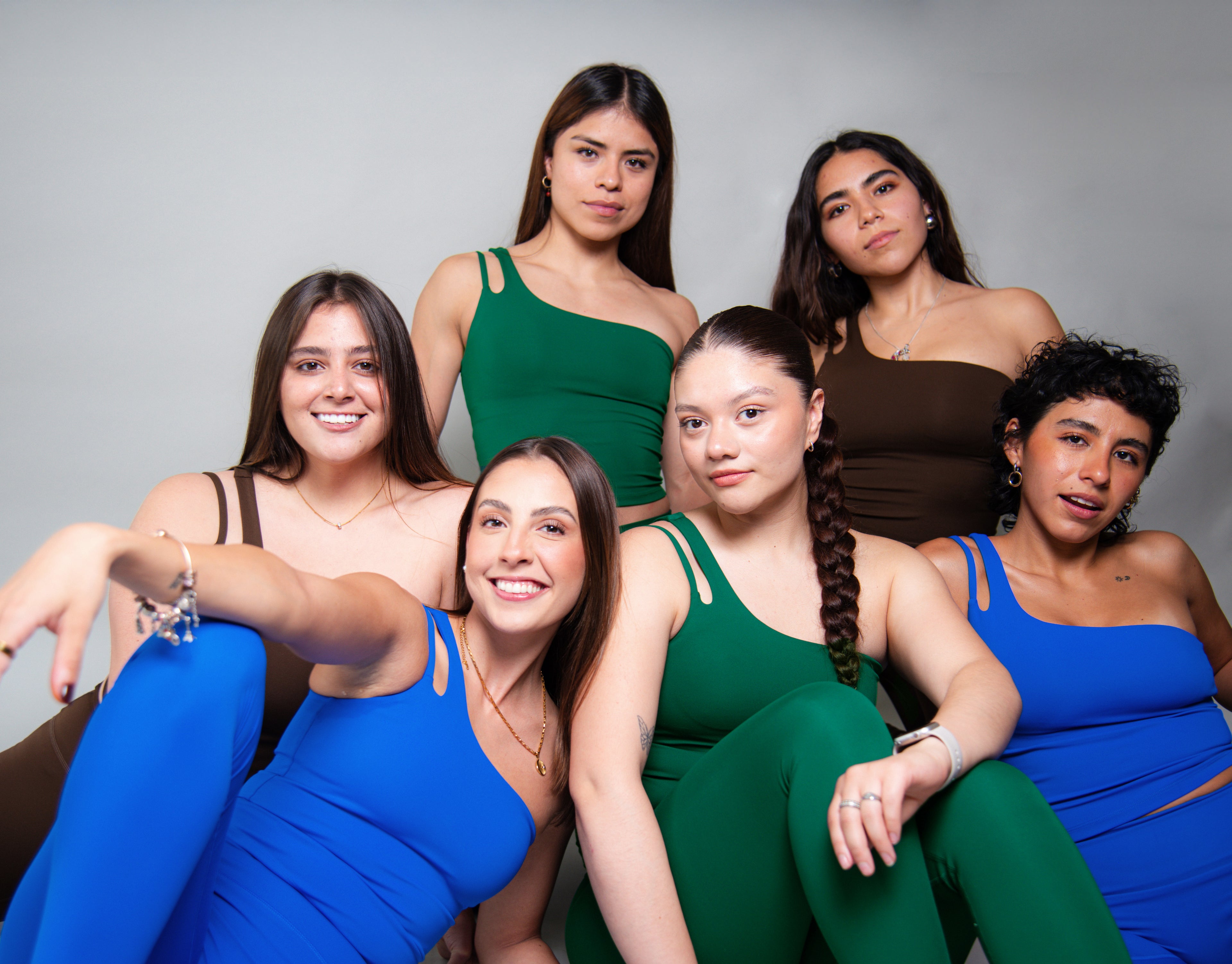 Grupo de mujeres usando conjuntos deportivos AC Sports en distintos colores, representación de cuerpos reales y diversidad en ropa deportiva