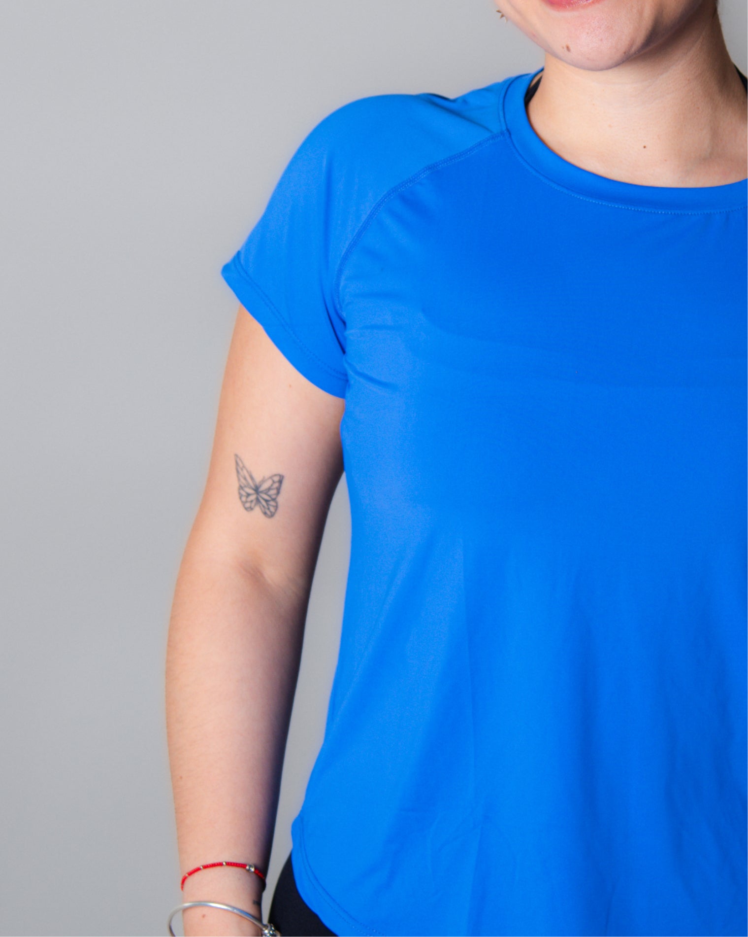 Blusa deportiva  azul de manga corta para mujer con diseño clásico y funcional, confeccionada en tela ligera, transpirable y de secado rápido, ideal para entrenamiento y uso activo diario.