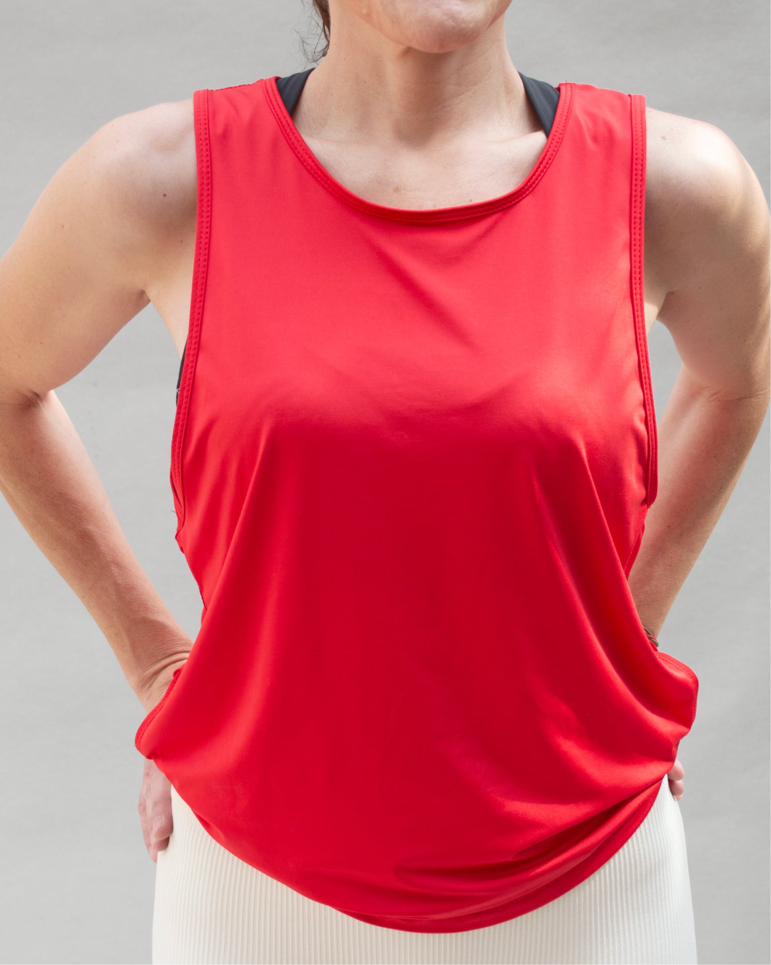 Blusa deportiva roja sin mangas de corte suelto para mujer, con diseño ligero y holgado que permite libertad de movimiento, ideal para entrenamiento, actividad física y uso diario, con ajuste cómodo y estilo minimalista.