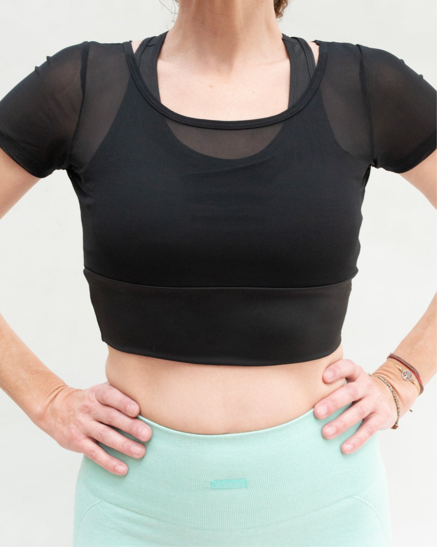 Blusa deportiva de manga corta para mujer con paneles de mesh transpirable, diseño ligero y ajuste cómodo, soporte ligero a medio y tela suave que se adapta al cuerpo, ideal para entrenamiento y uso activo diario.