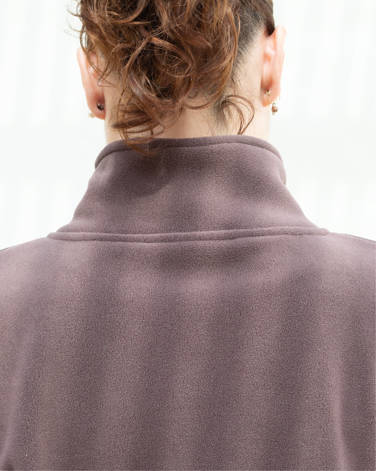 Chamarra deportiva oversize para mujer en tono café con cierre frontal y ajuste inferior regulable, confeccionada en tela afelpada de tacto suave, ideal para brindar abrigo ligero y comodidad antes o después del entrenamiento.