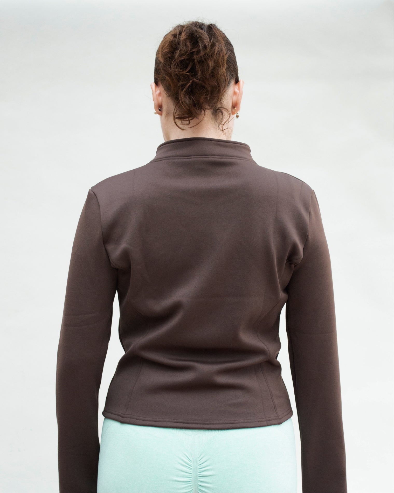 Chamarra deportiva AC Sports color café con cierre frontal completo y cuello alto, diseño anatómico de manga larga con ajuste medio que estiliza la silueta.