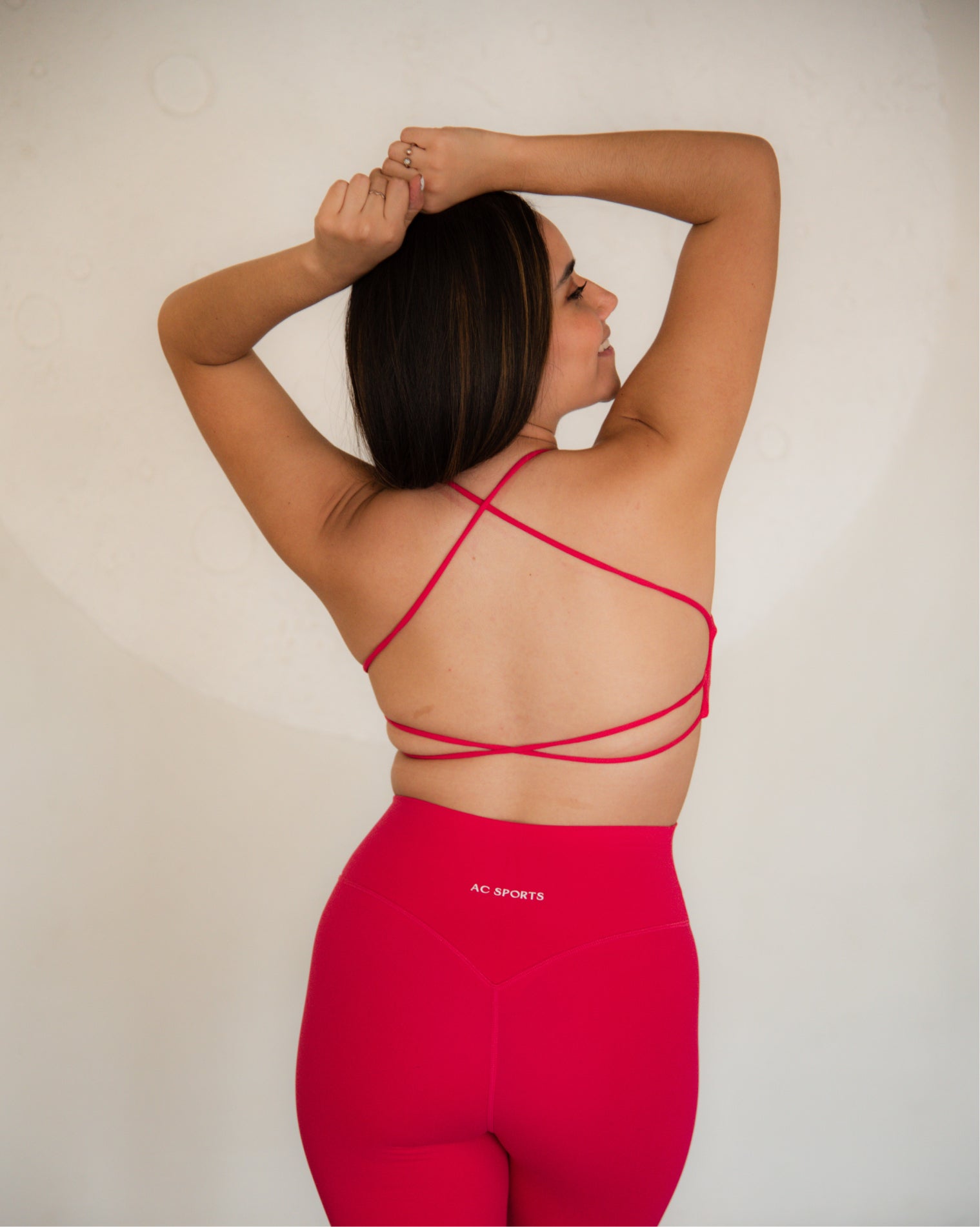 Top deportivo Magenta para mujer con tirantes finos y escote recto, ajuste ceñido al cuerpo y acabado liso, con logo AC Sports al frente. Combinado con leggings de tiro alto, ideal para entrenamientos de bajo impacto y uso diario.