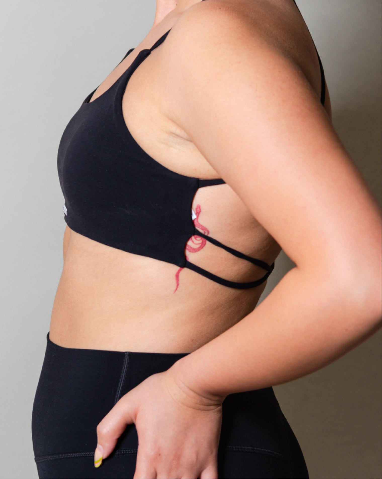 Top deportivo Negro para mujer con tirantes finos y escote recto, ajuste ceñido al cuerpo y acabado liso, con logo AC Sports al frente. Combinado con leggings de tiro alto, ideal para entrenamientos de bajo impacto y uso diario.