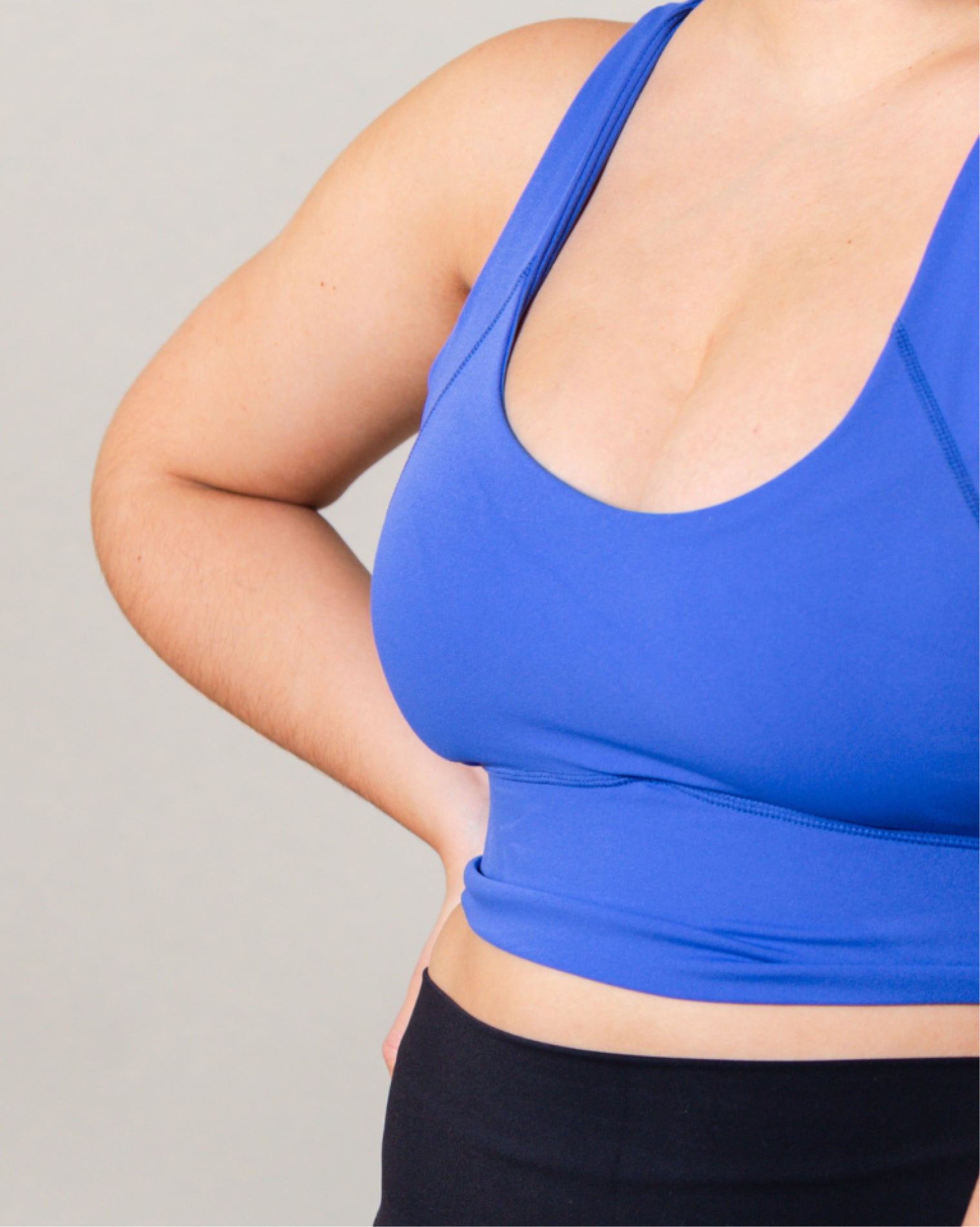 Top deportivo Azul para mujer con tirantes anchos, escote en forma de V y ajuste ceñido al cuerpo, diseño liso con banda inferior visible que aporta un ajuste firme, ideal para entrenamiento y uso diario.