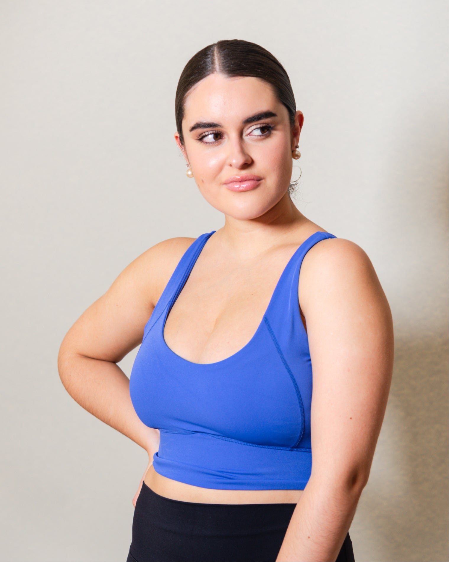 Top deportivo Azul para mujer con tirantes anchos, escote en forma de V y ajuste ceñido al cuerpo, diseño liso con banda inferior visible que aporta un ajuste firme, ideal para entrenamiento y uso diario.