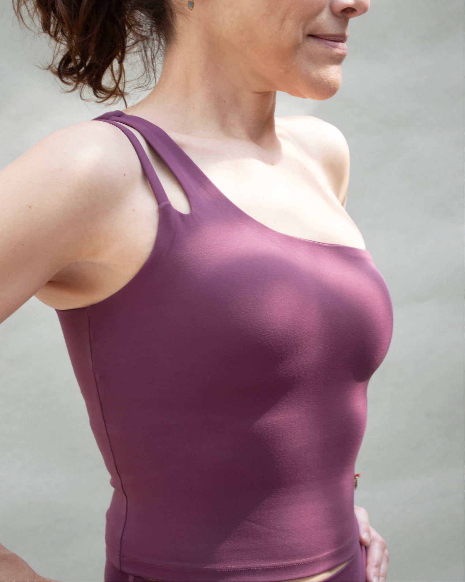 Top deportivo Sienna color vino, diseño ajustado con escote recto y tirantes asimétricos.
