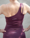Top deportivo Sienna color vino, diseño ajustado con escote recto y tirantes asimétricos.