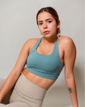Top deportivo Turquesa para mujer AC Sports, con tirantes cruzados en la espalda y soporte alto impacto, ideal para entrenamiento, yoga y gimnasio, combinado con leggings de tiro alto.