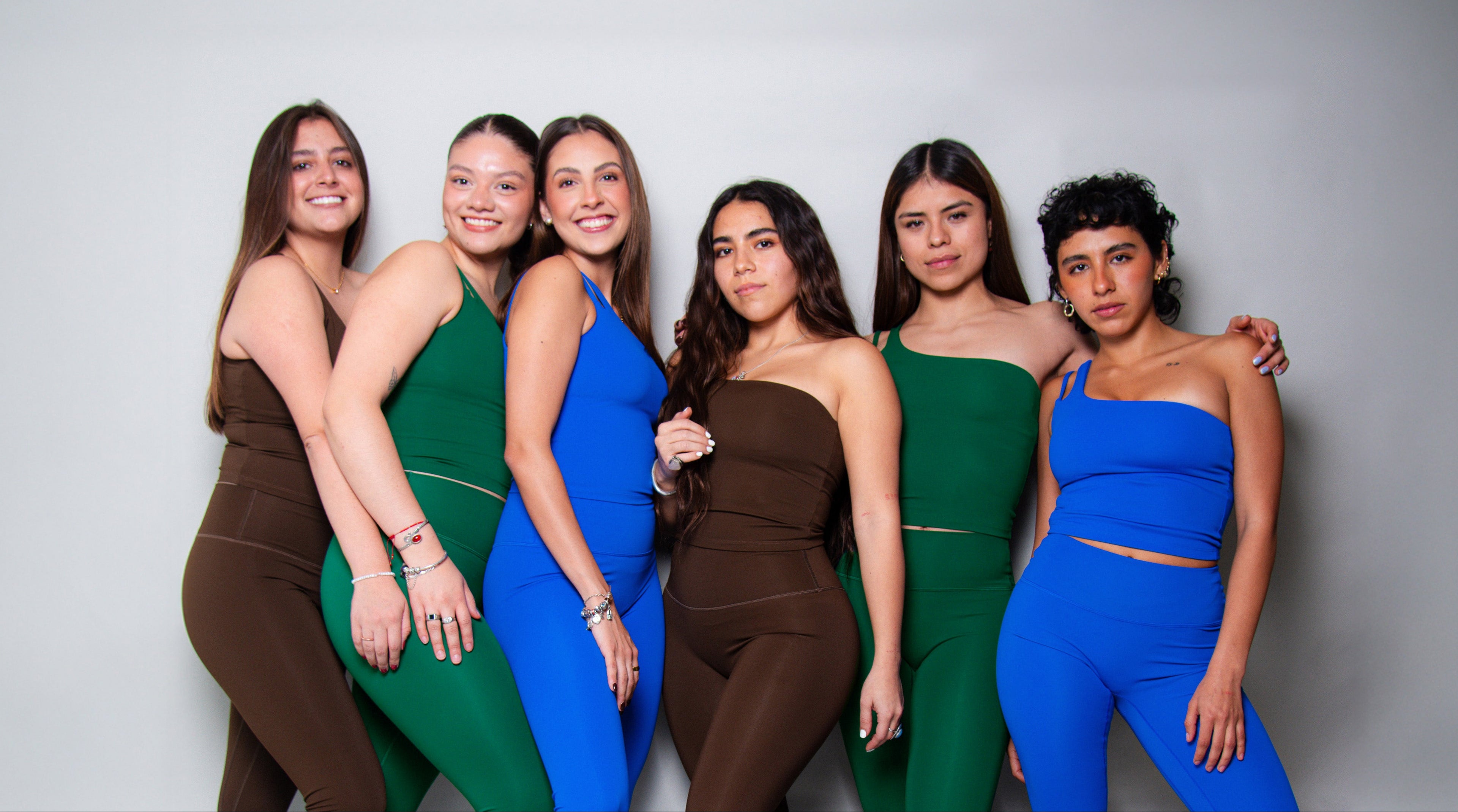 Mujeres usando conjuntos deportivos AC Sports en tonos verde, azul y café, ropa deportiva cómoda y funcional para entrenamiento y uso diario