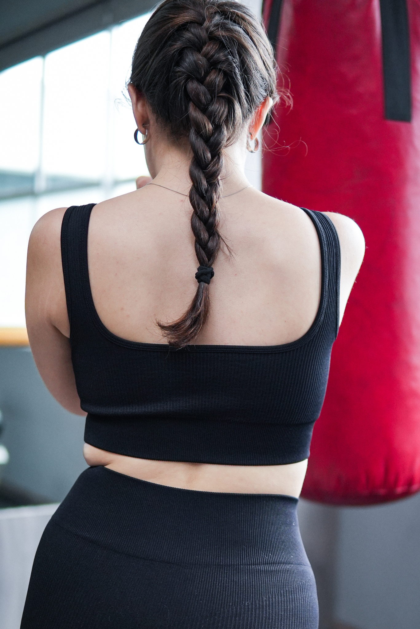 Top deportivo negro para mujer de diseño básico con tirantes anchos, tela acanalada visible y ajuste ceñido al cuerpo, estilo deportivo versátil ideal para entrenamiento y uso diario.