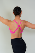 Top deportivo AC Sports color rosa con espalda descubierta y tirantes delgados ajustables, diseño cruzado en la espalda que realza la silueta.